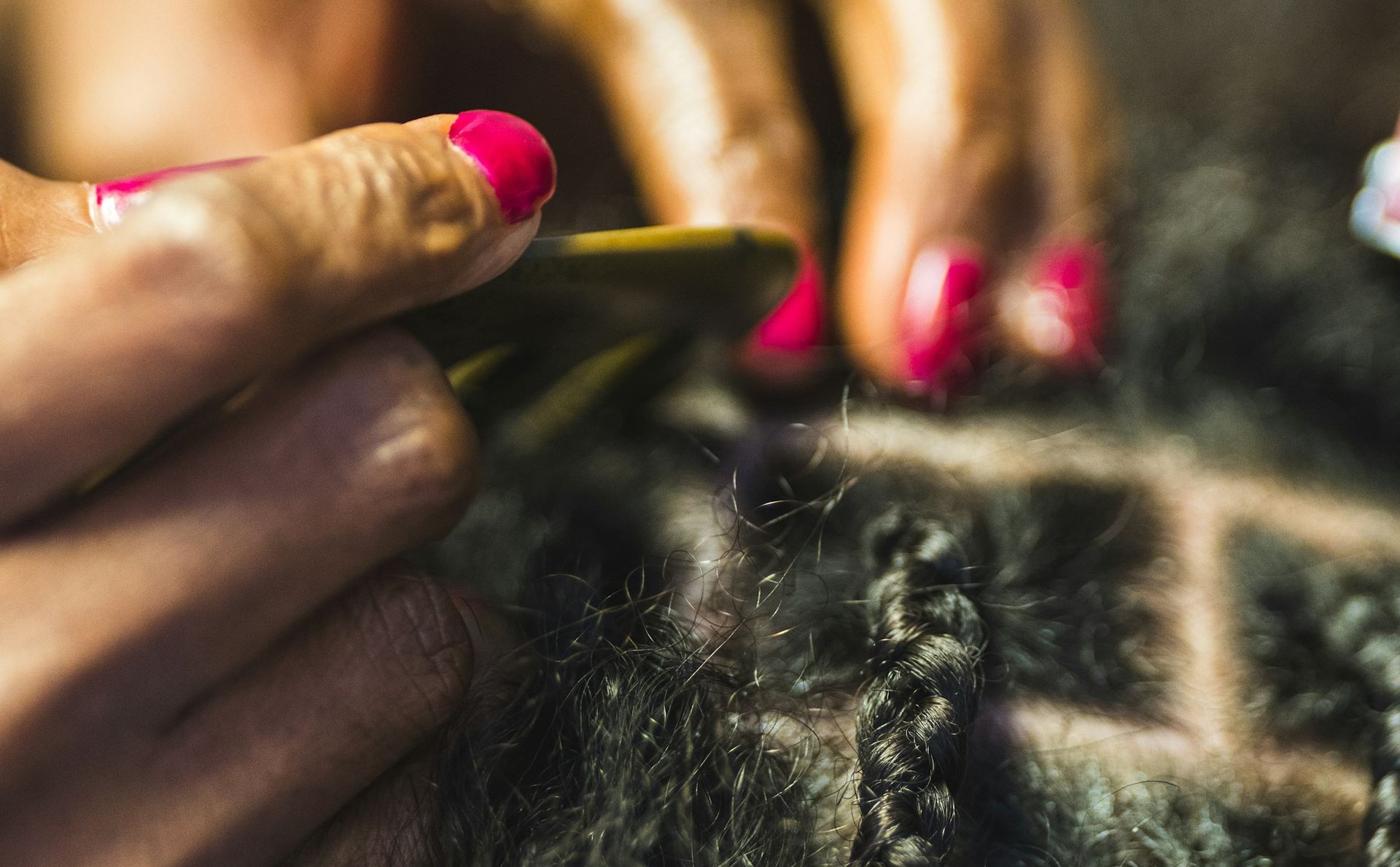 A stylist's hands braiding neat square sections (sample photo)
